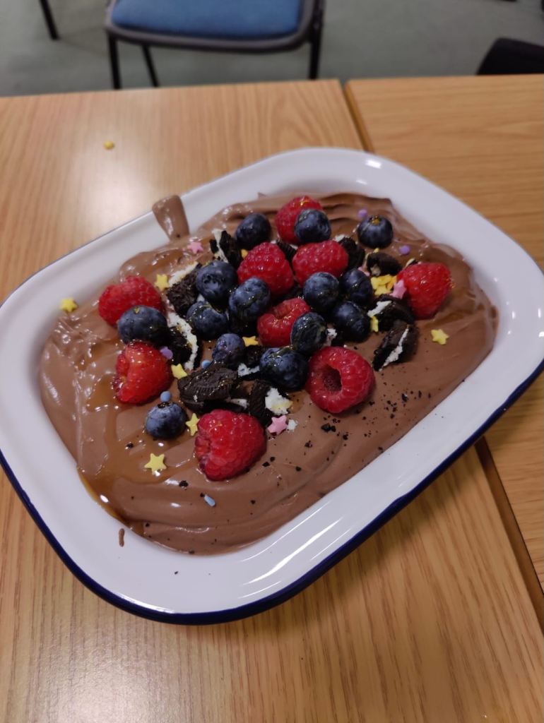 Photo of the mouse with blueberries and raspberries on top. 